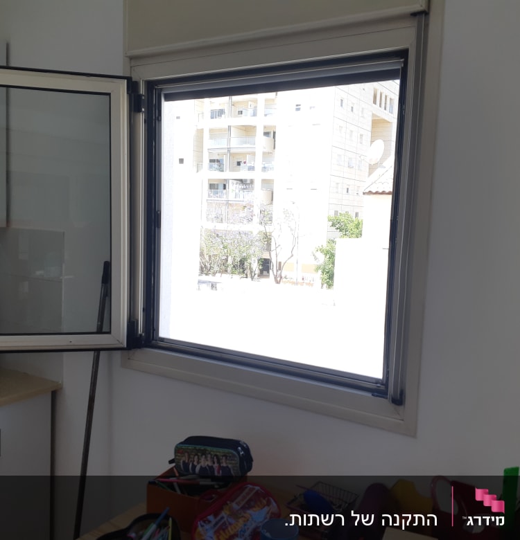 חלון אלומיניום פתוח עם מסגרת אפורה